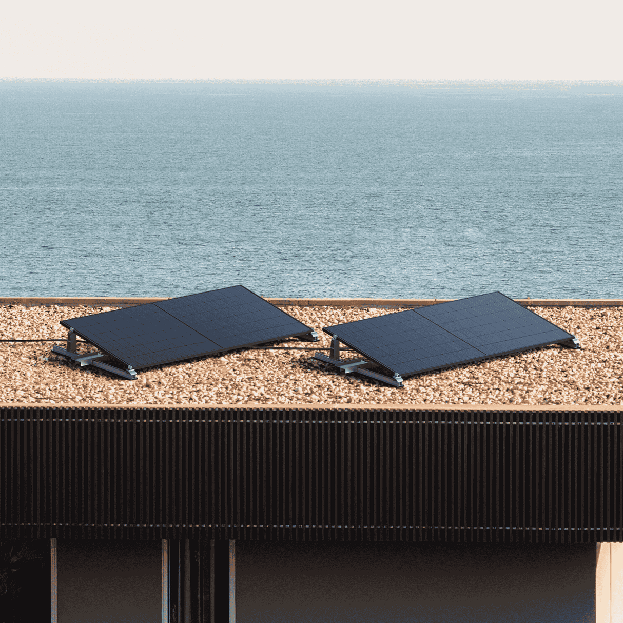 Balkonkraftwerk mit Solarmodulen auf einem Flachdach mit Blick auf das Meer